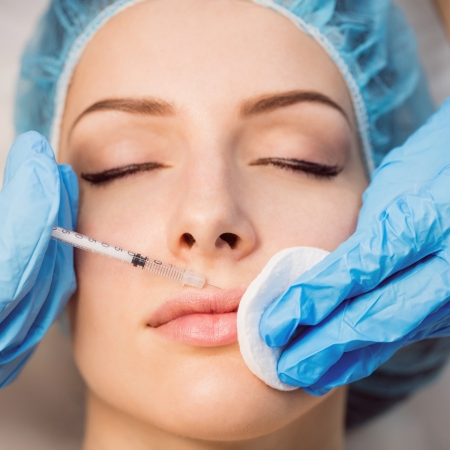Close-up of female patient receiving an injection on her face in clinic