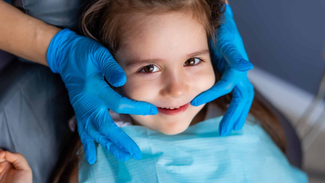 child-with-blue-gloves-is-getting-her-teeth-checked